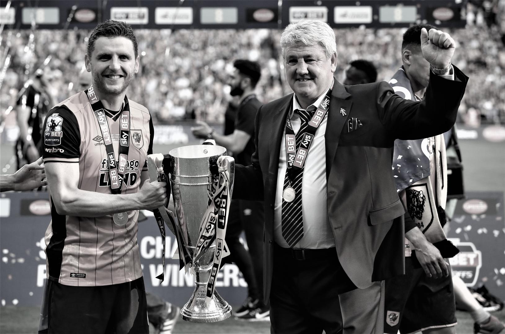 Alex Bruce and his dad Steve Bruce celebrate with the Championship play-off trophy after winning the final with Hull City