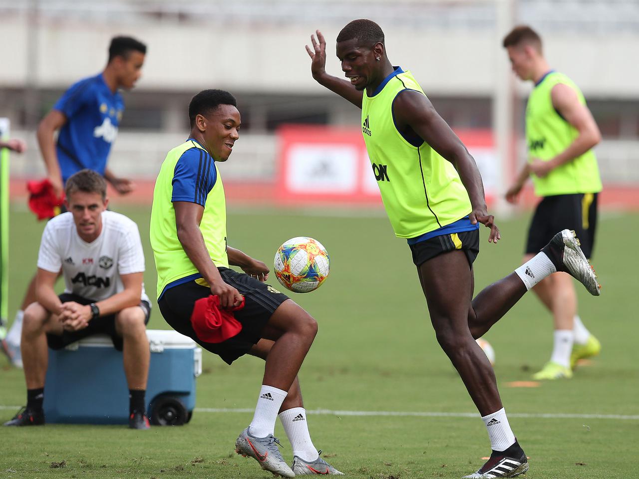 Anthony Martial and Paul Pogba comepete for a ball at training in Shanghai.