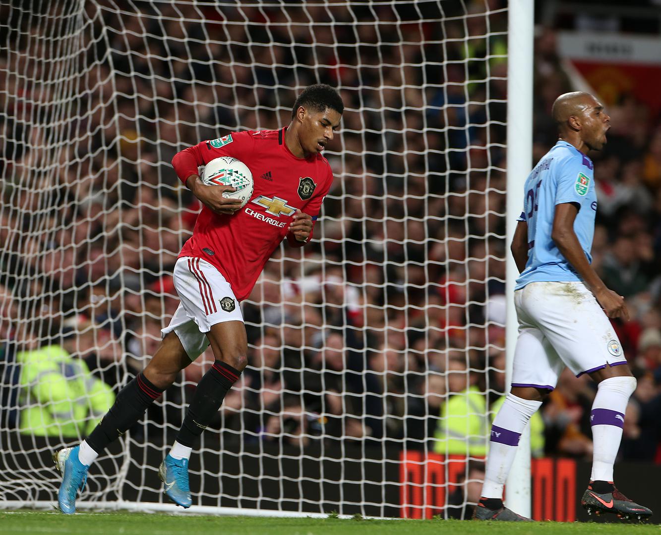 Marcus Rashford picks the ball out of the net after scoring against Man City