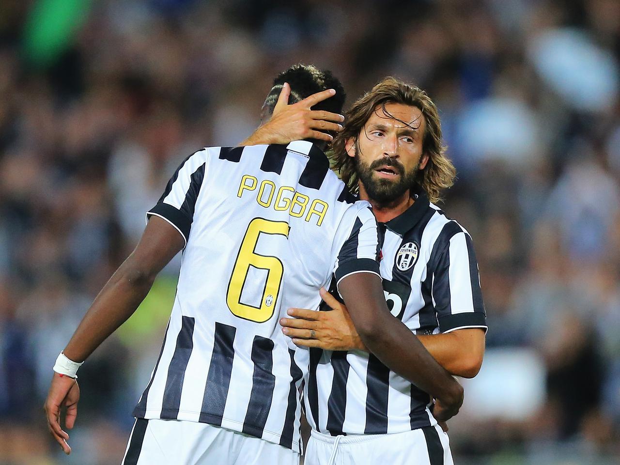 Paul Pogba is hugged by Andrea Pirlo.